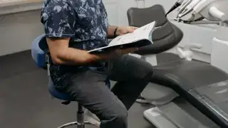 Dentist reviewing a patient file in a clinic for an adult dental insurance comparison guide