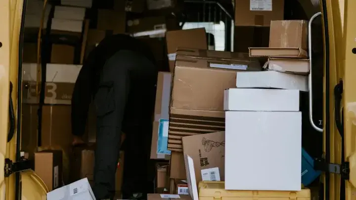 Worker loading packages into a business delivery van, illustrating commercial auto insurance exposures