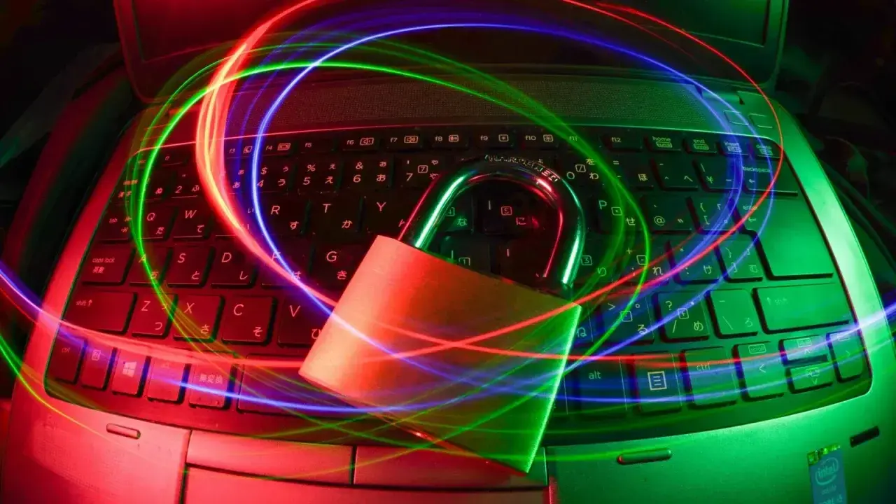 Padlock on a laptop with light trails, illustrating cyber insurance security controls