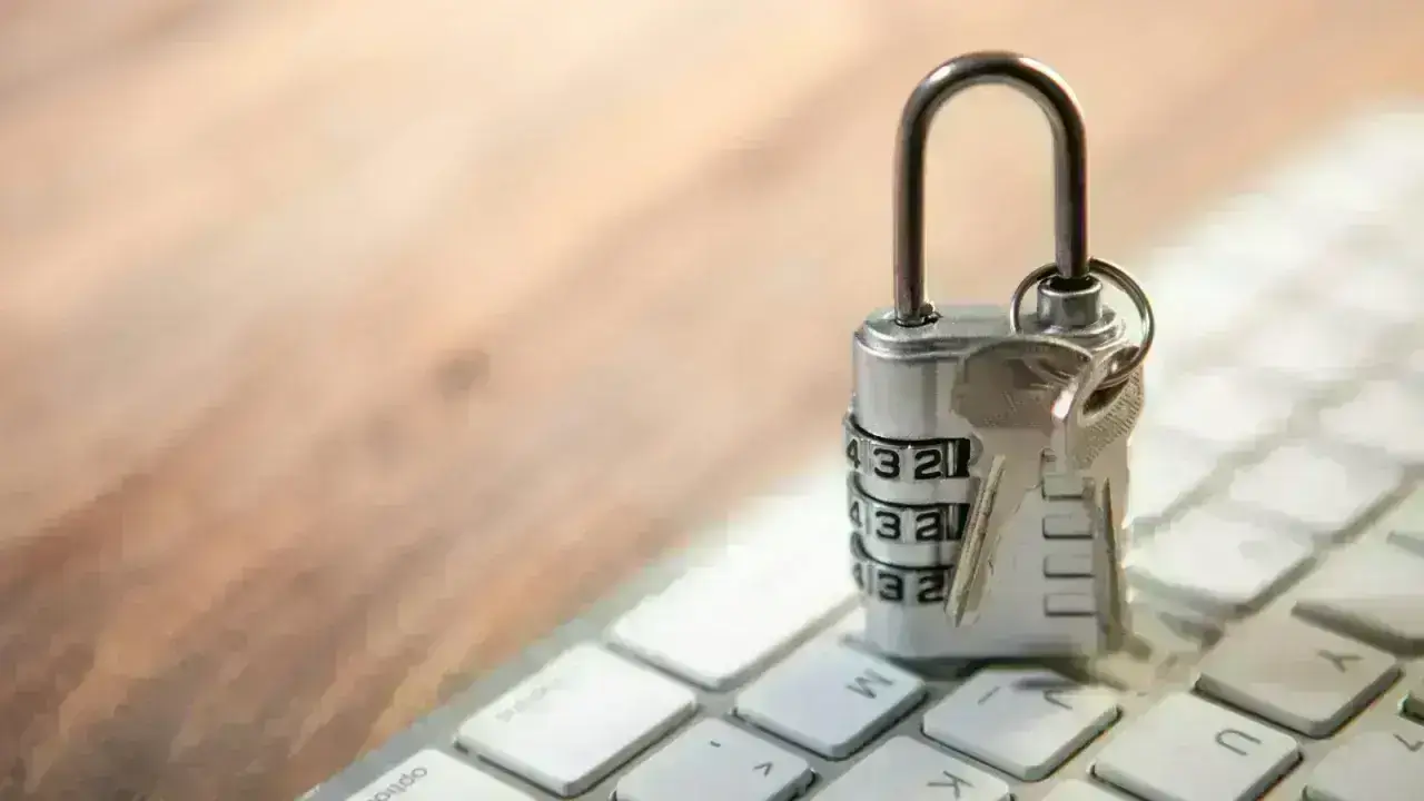 Padlock and keys on a computer keyboard representing cybersecurity and cyber insurance