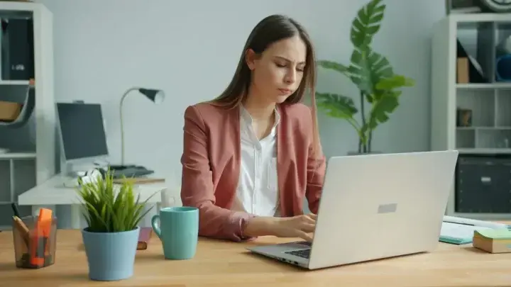 Tired office worker at a laptop, illustrating income risk when illness or injury prevents work