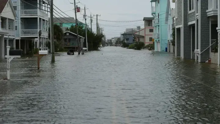 Flood water covering a residential street between homes in the United States