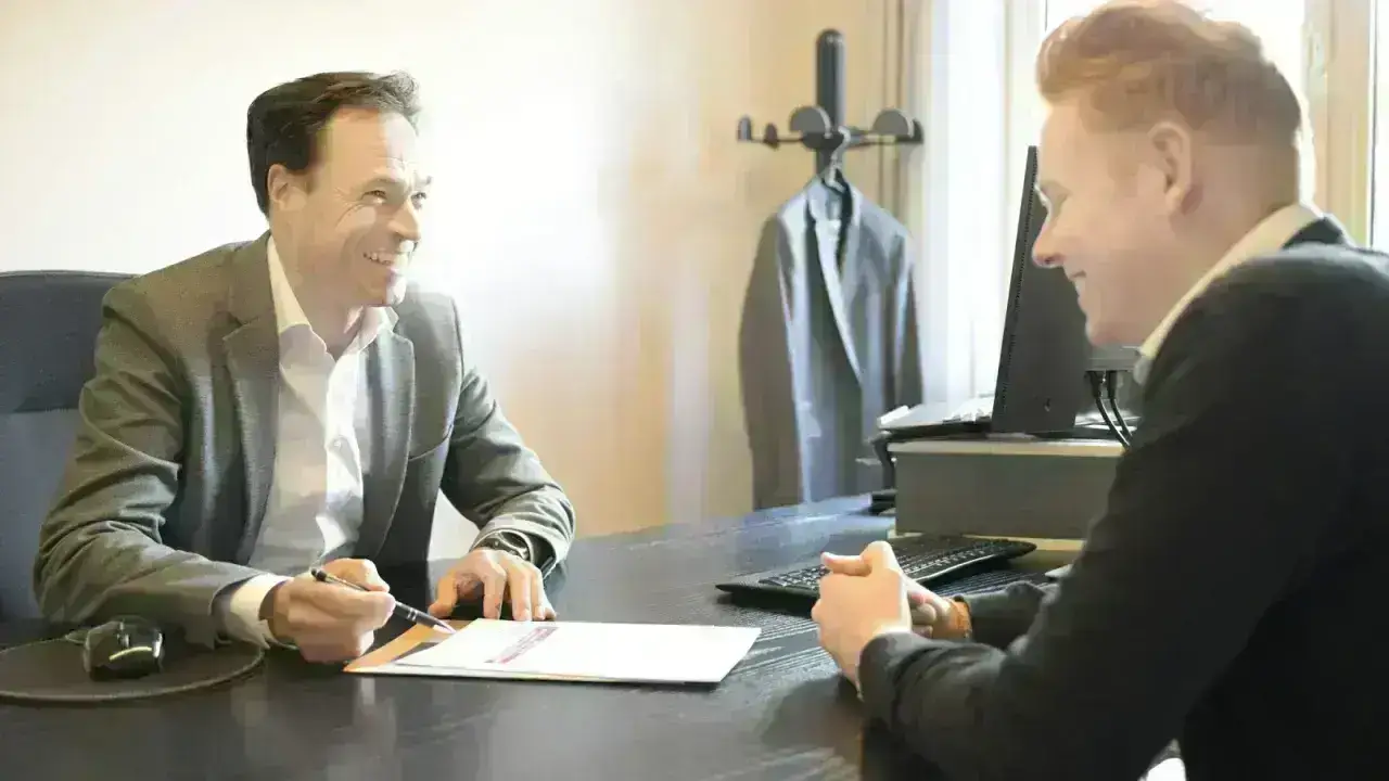 Insurance professional discussing documents with a client in an office