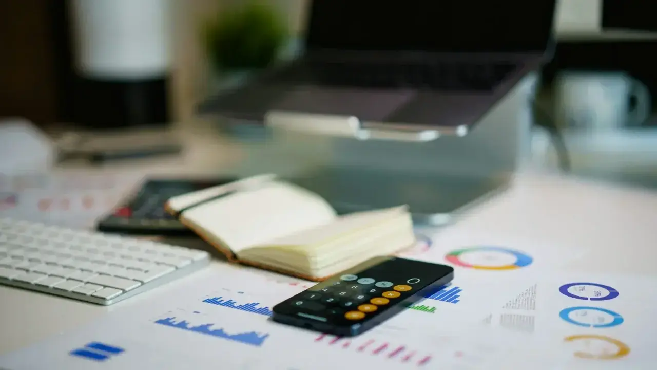 Financial charts and calculator on an office desk, illustrating excess-of-loss reinsurance structure and loss aggregation