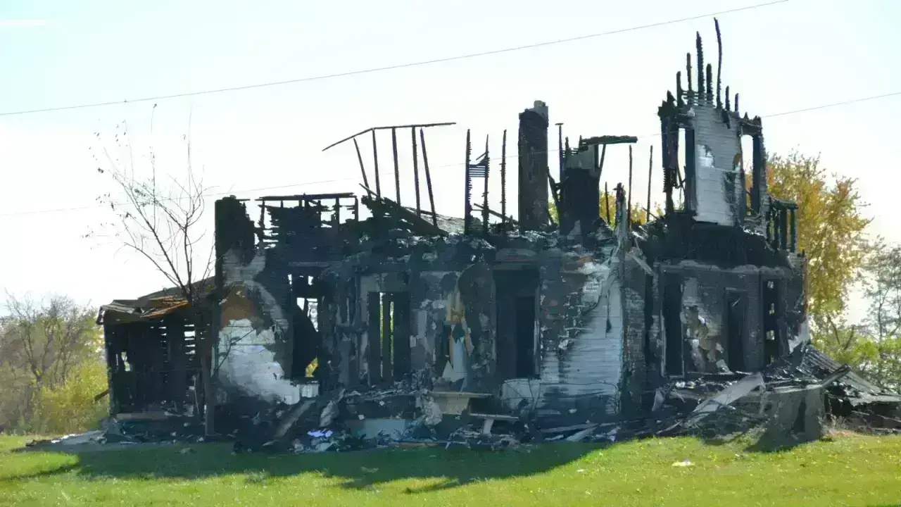 A home destroyed by fire, illustrating the difference between replacement cost and actual cash value claim settlements