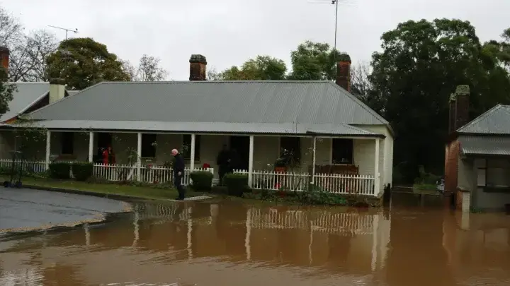 Flood water approaching a house, illustrating the difference between flood and other water damage coverage
