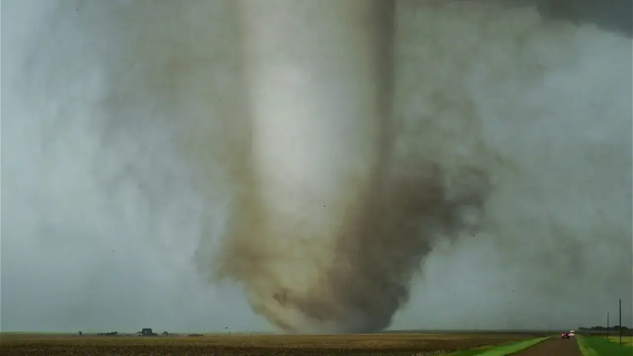 Storm clouds and a tornado near a home, illustrating catastrophe risk for homeowners insurance