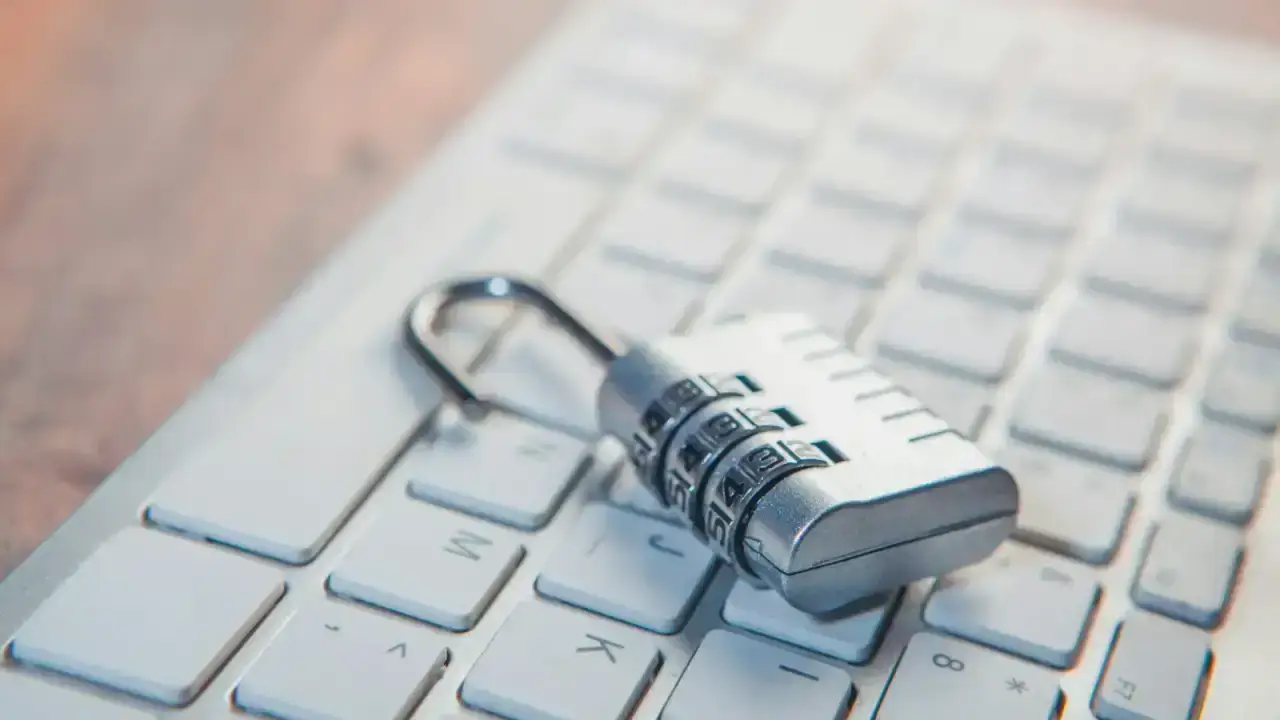 Combination lock on a computer keyboard illustrating account takeover and personal cyber protection