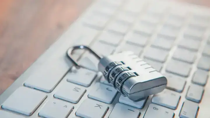 Combination lock on a computer keyboard illustrating account takeover and personal cyber protection