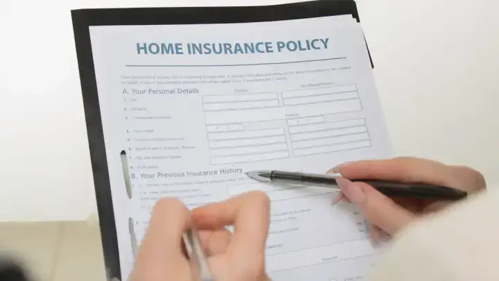 Home insurance documents being reviewed for a C.L.U.E. claims history report consumer guide