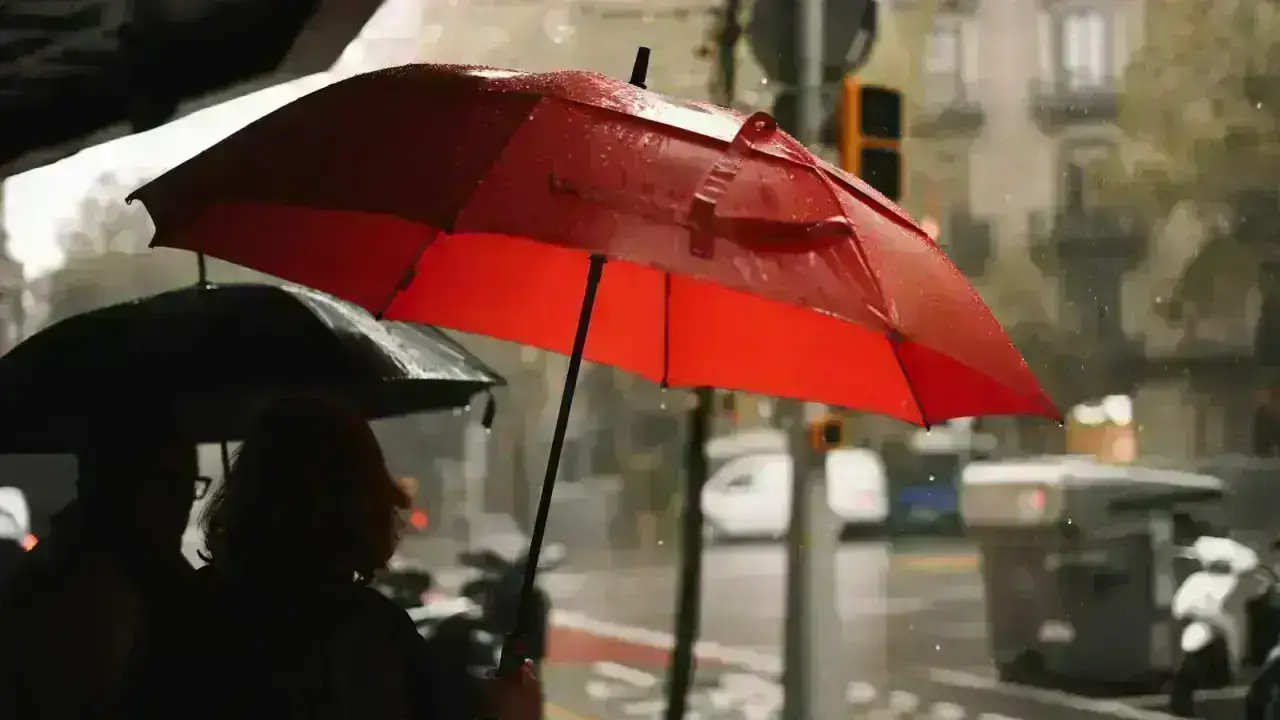 People sheltering under umbrellas in heavy rain, illustrating commercial umbrella and excess liability protection