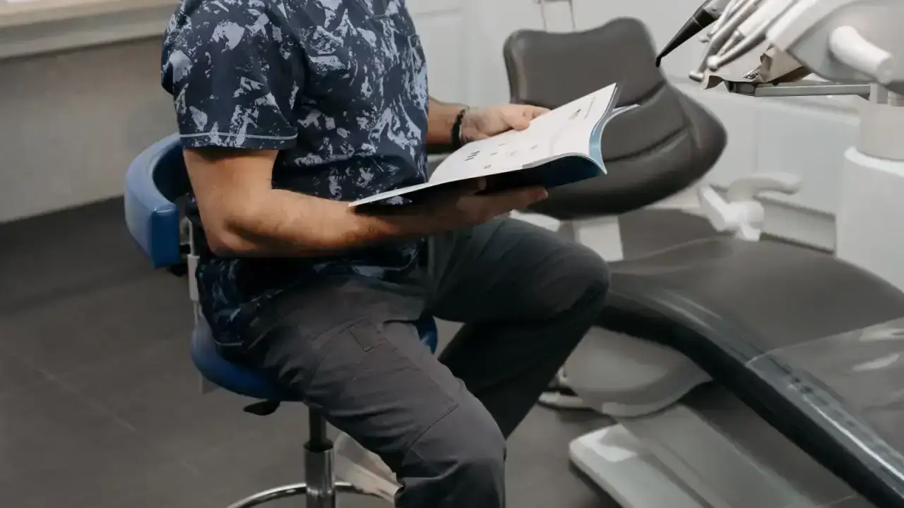 Dentist reviewing a patient file in a clinic for an adult dental insurance comparison guide
