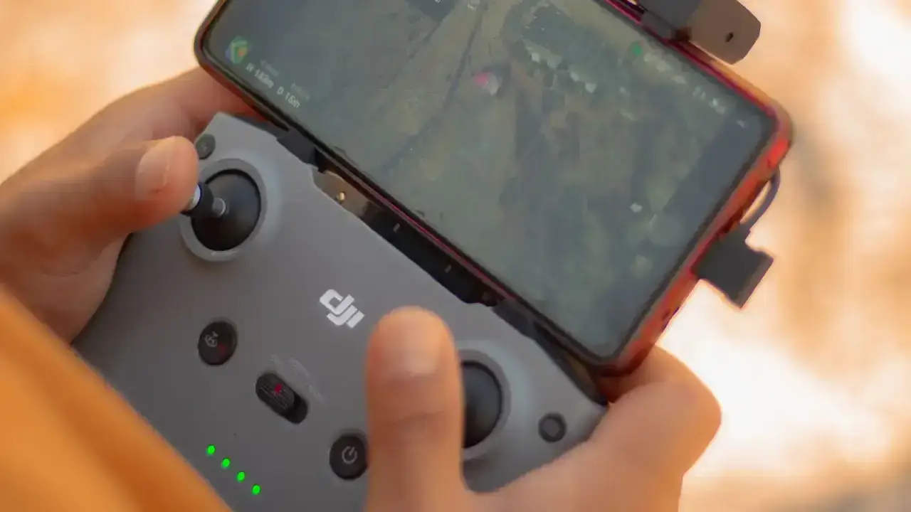 Commercial drone operator using a controller and smartphone while preparing a business flight