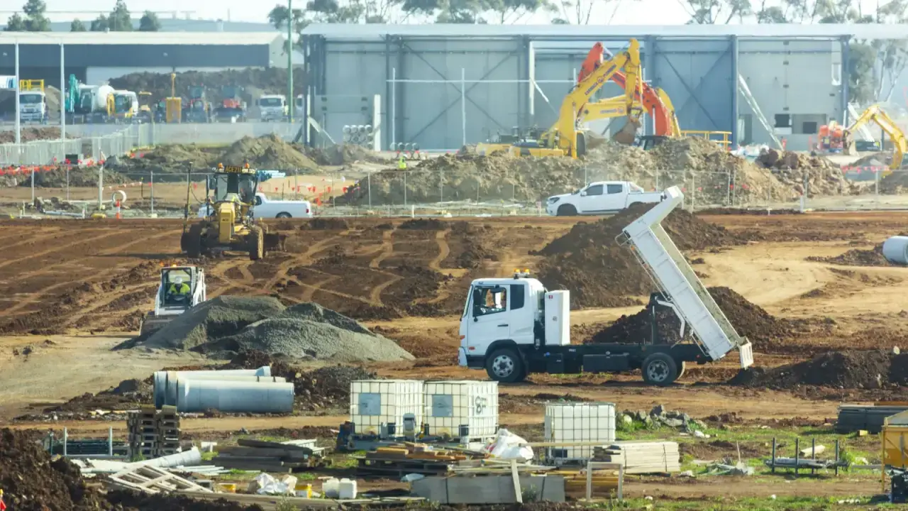 Construction site with trucks and movable equipment, illustrating inland marine insurance for business tools and property in transit