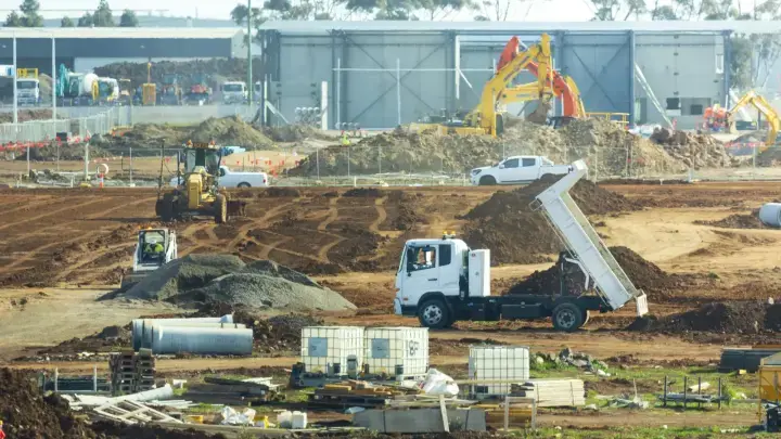 Construction site with trucks and movable equipment, illustrating inland marine insurance for business tools and property in transit
