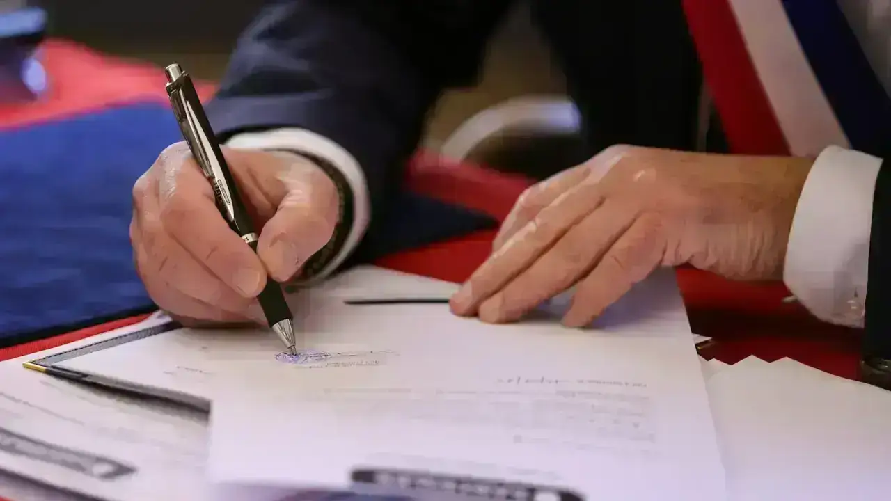 Businesspeople signing an agreement at a table, illustrating a temporary insurance binder before the full policy is issued
