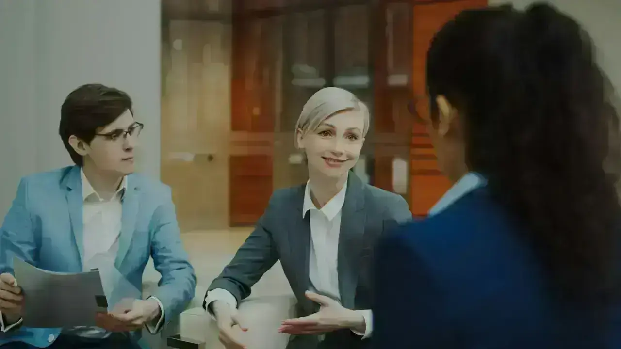 Insurance professionals discussing documents in a meeting, illustrating state market conduct examinations and compliance review
