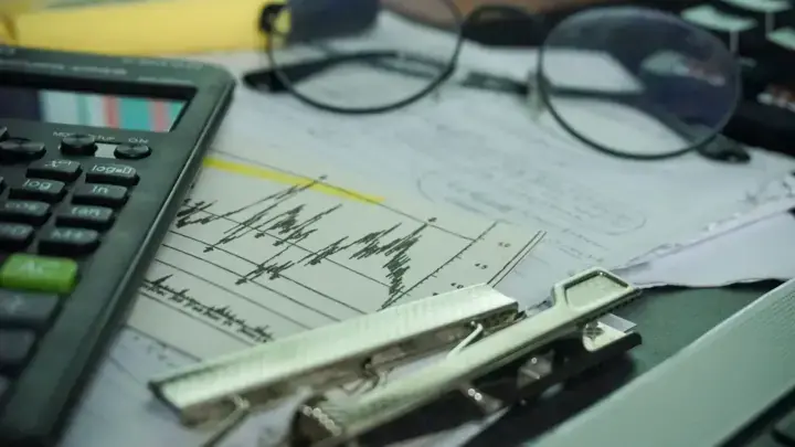 Financial-analysis desk with calculator and reports, illustrating reserve-risk modeling for loss portfolio transfers and adverse development covers