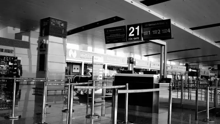 Airport departure gate and flight display, illustrating missed connection travel insurance after a delayed flight