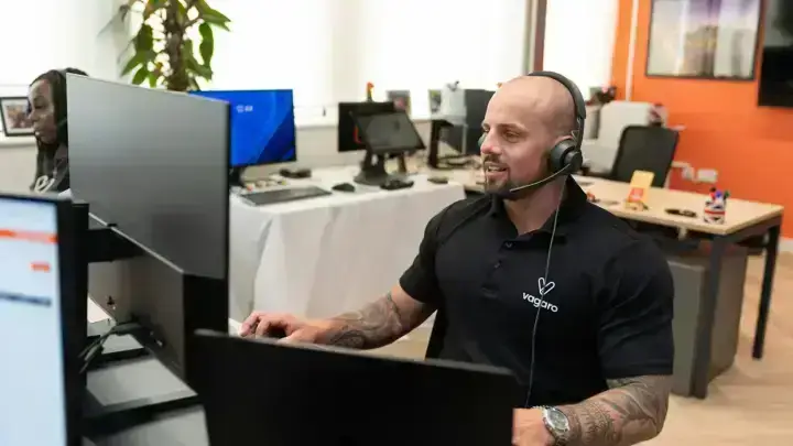 Customer service representative at a computer illustrating insurance company complaint research and consumer support