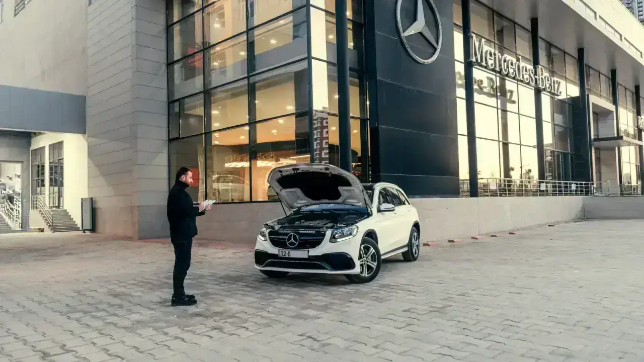 Driver inspecting a newer car at a dealership, illustrating new car replacement insurance after a total loss