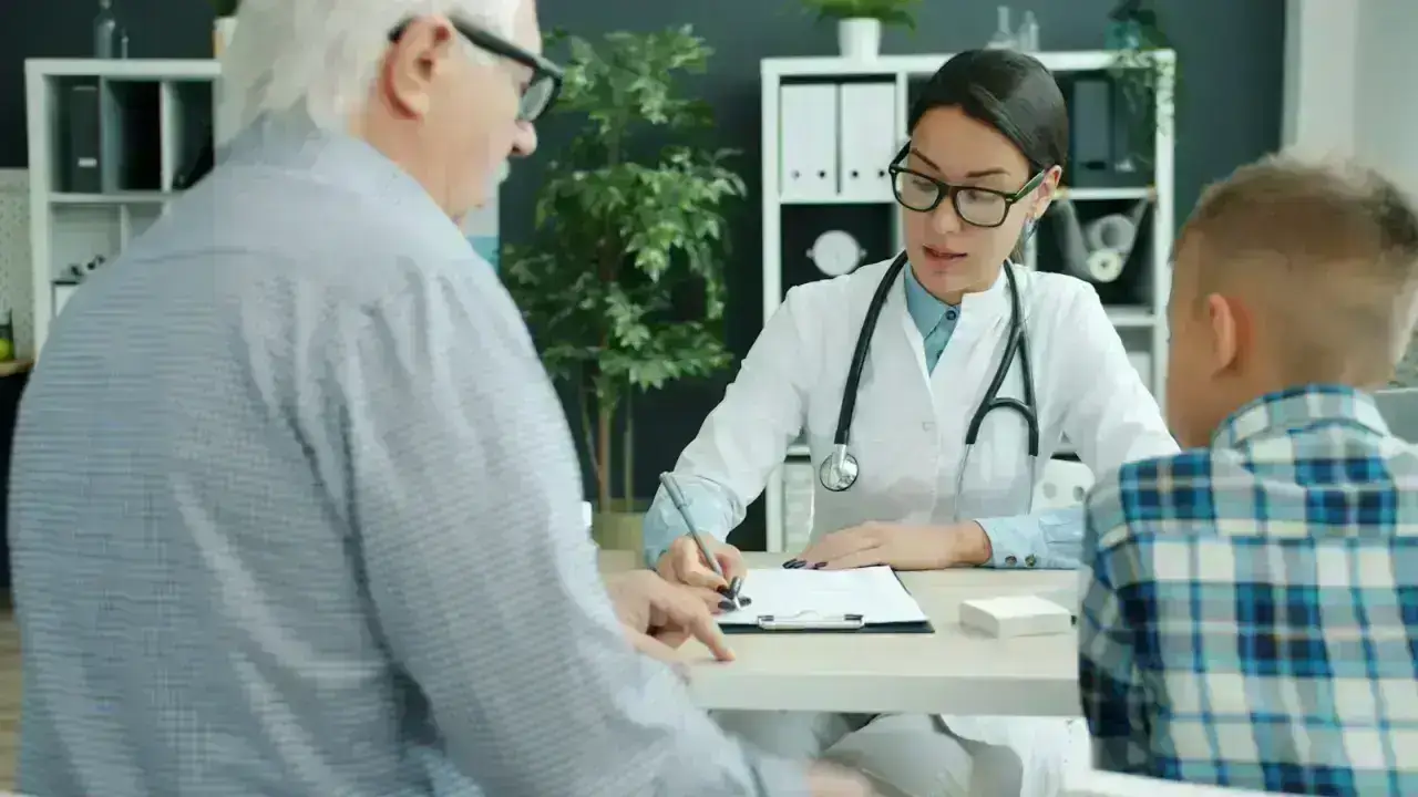 Doctor consulting with patients in a medical office, illustrating No Surprises Act protections for health insurance bills