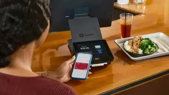 Customer making a digital payment at a cafe, illustrating PCI DSS payment card security and cyber insurance exposure