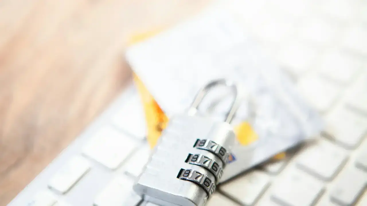 Padlock, payment cards and computer keyboard illustrating personal cyber insurance for online fraud and digital risks