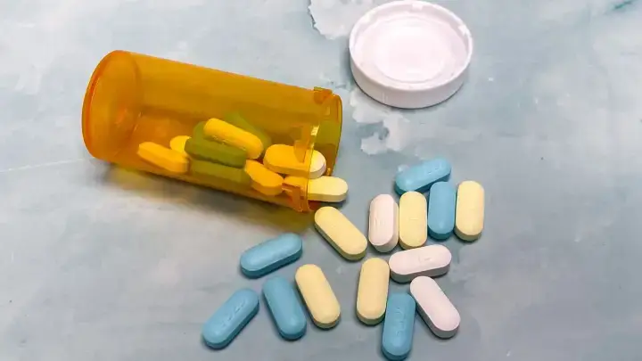 Prescription bottle and pills illustrating health insurance drug formulary tiers and coverage rules