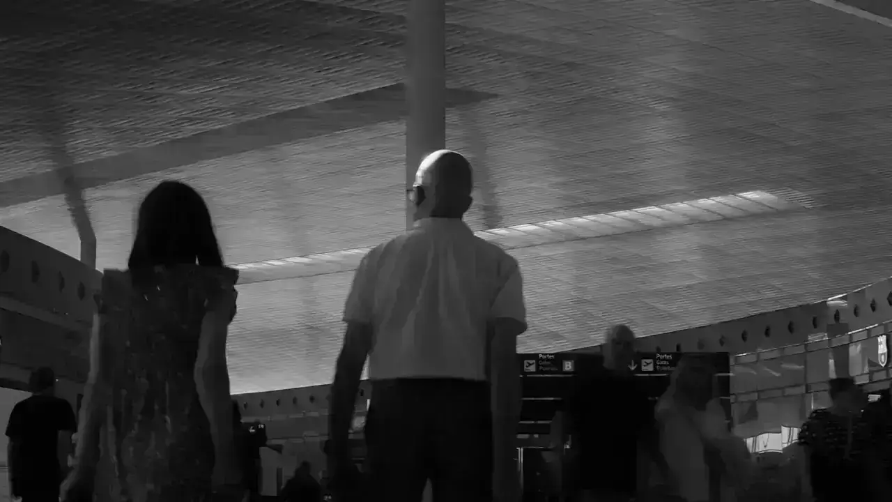 Travelers walking with luggage through a modern airport terminal illustrating international travel medical insurance