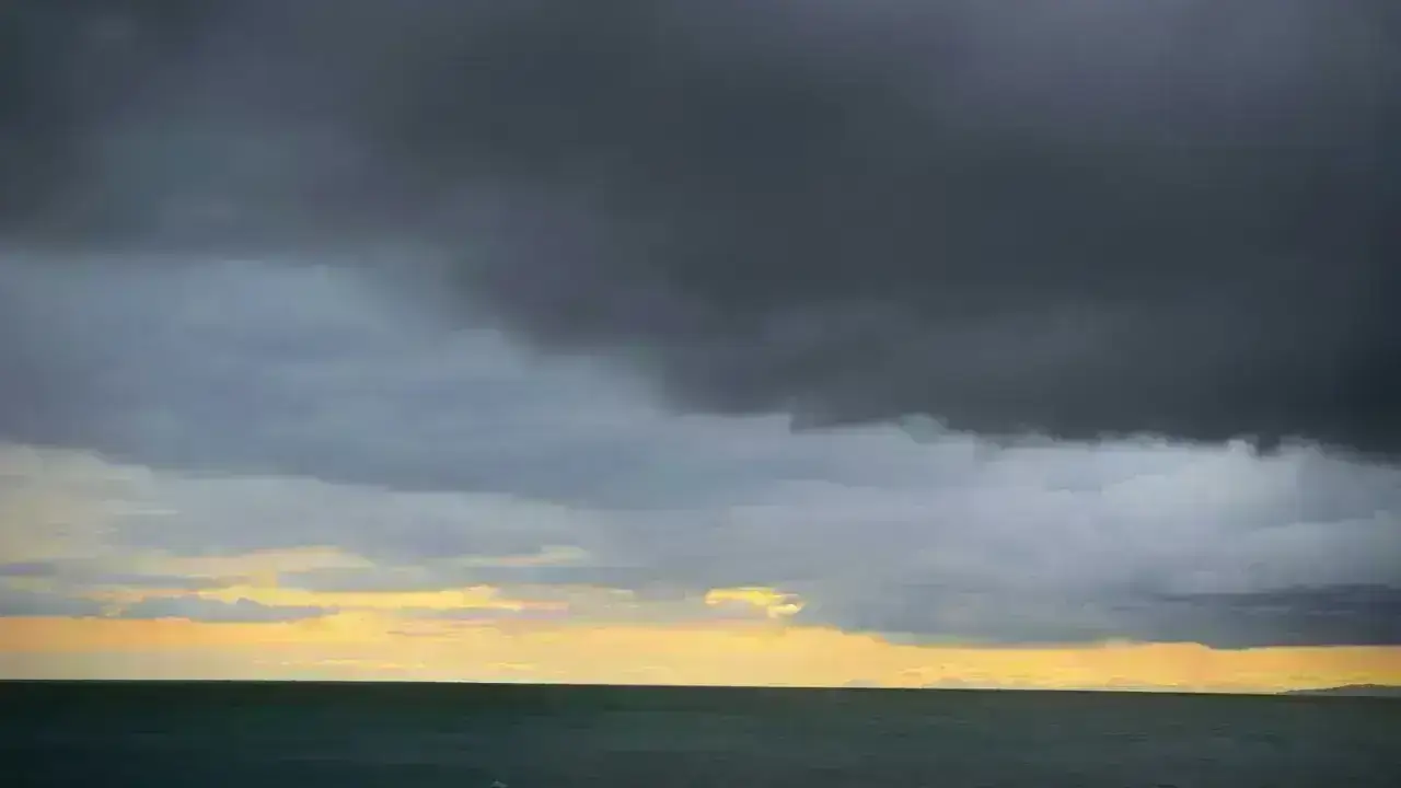 Dark storm clouds over the ocean, illustrating catastrophe excess-of-loss reinsurance and reinstated capacity
