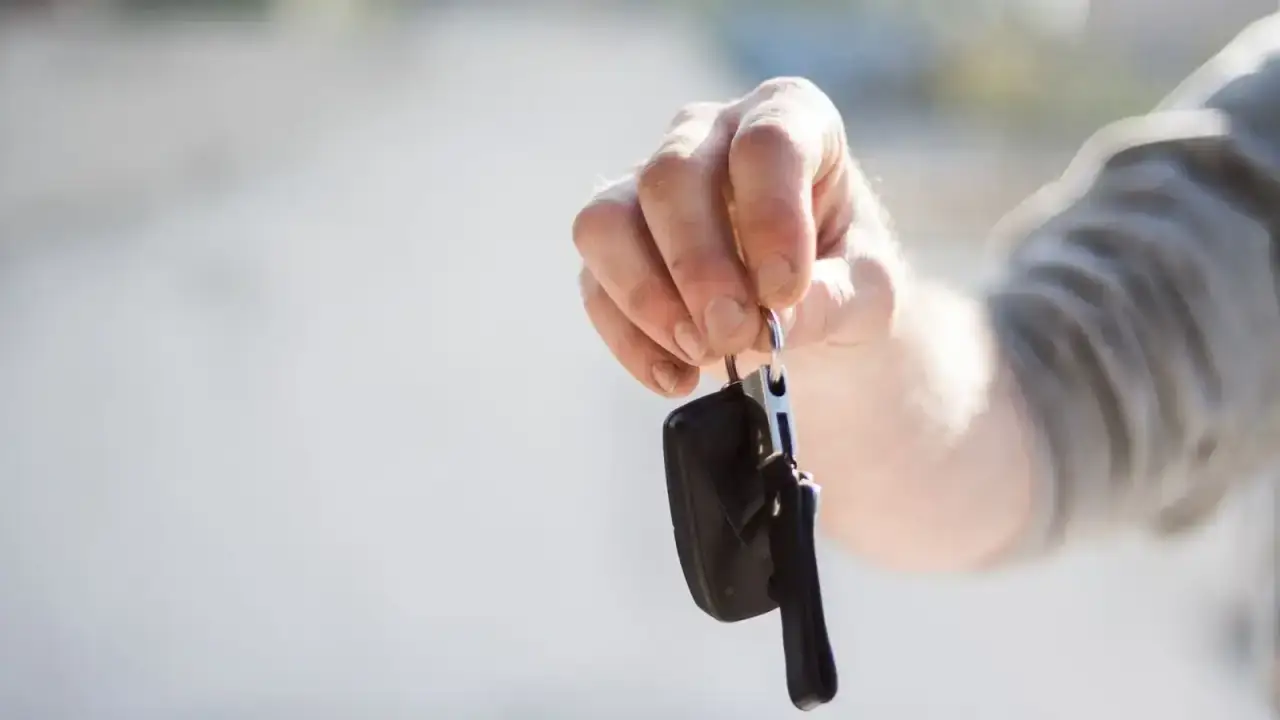 Handing over car keys illustrating rental car damage coverage and travel insurance choices