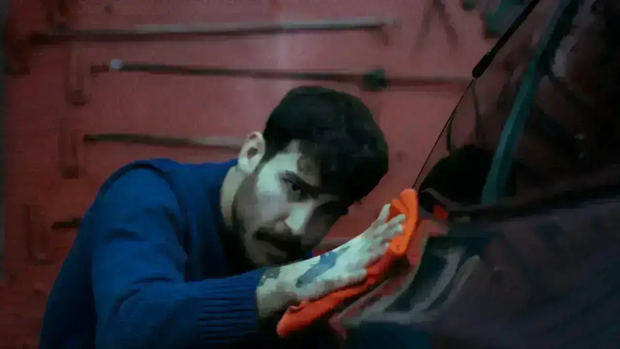 Mechanic working on a car in a garage, illustrating rental reimbursement while an insured vehicle is being repaired