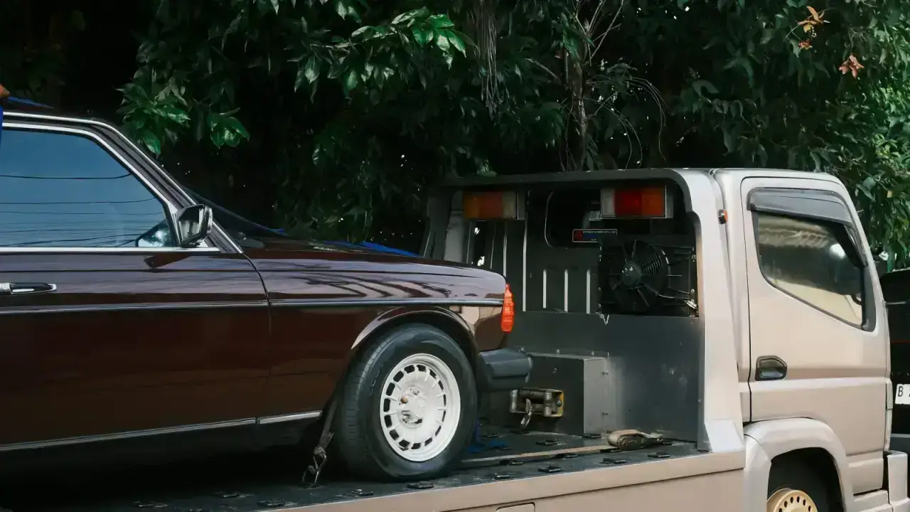 Car secured on a flatbed tow truck, illustrating roadside assistance and towing coverage