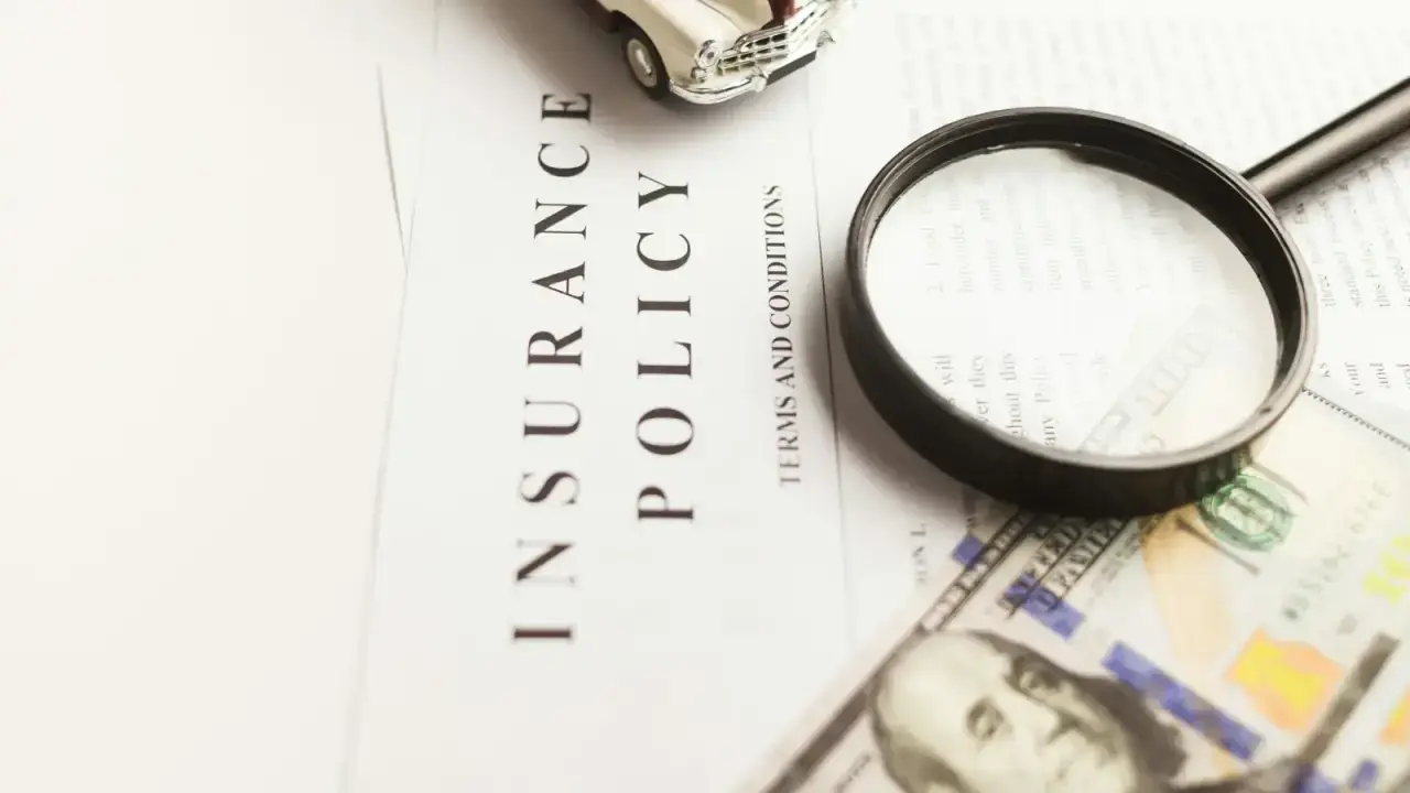 Motor insurance certificate and policy documents under a magnifying glass, illustrating SR-22 and FR-44 financial responsibility filings