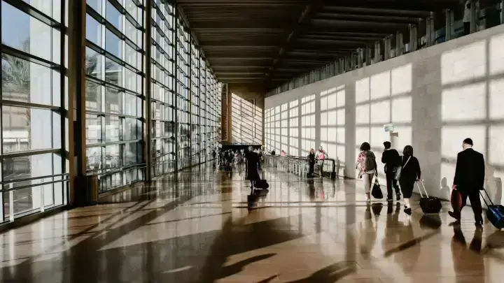 Travelers at an airport illustrating trip insurance for terrorism civil unrest and travel advisories